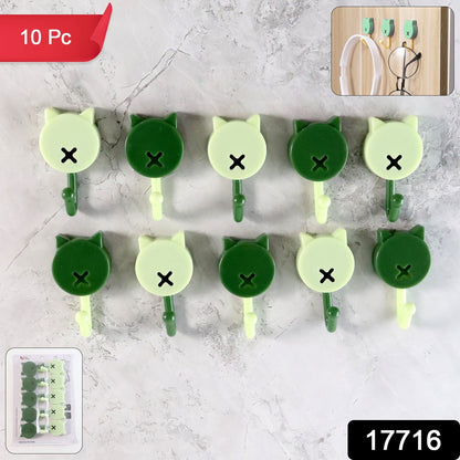 Ten cat-shaped wall hooks in dark and light green against a grey marble background, with an inset of the hooks in use.