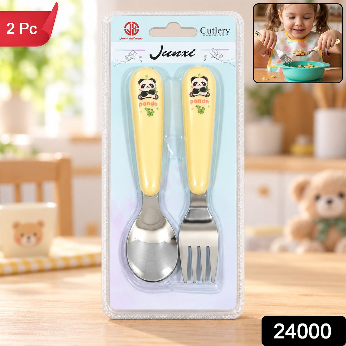 A yellow and silver panda-themed spoon and fork set is packaged in clear plastic on a wooden table, with a small image of a
