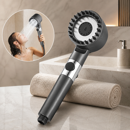 A dark gray shower head with a wide face and rubber bristles, next to a rolled towel, with an inset of a woman showering.