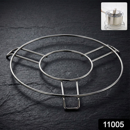 A shiny silver wire hot pot stand rests on a dark slate surface, with a small inset of a pot on the stand.