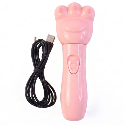 A pink bear paw shaped massager with a power button and its coiled black USB charging cable are on a white background.