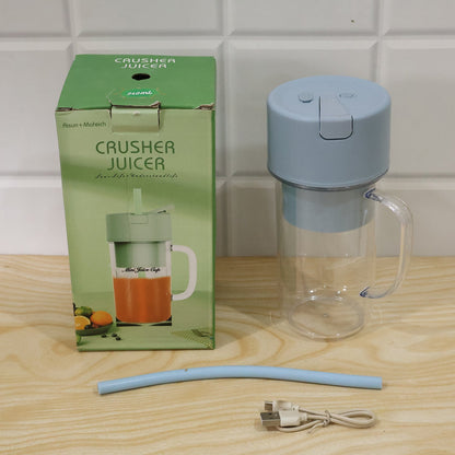 A light blue portable blender, blue straw, and USB cable are next to a green box labeled "Crusher Juicer".
