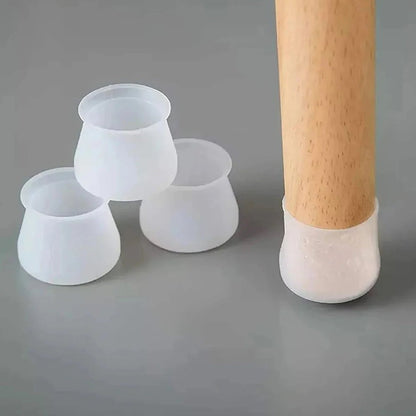Three translucent silicone furniture leg protectors next to a wooden leg with one applied, on a gray surface.