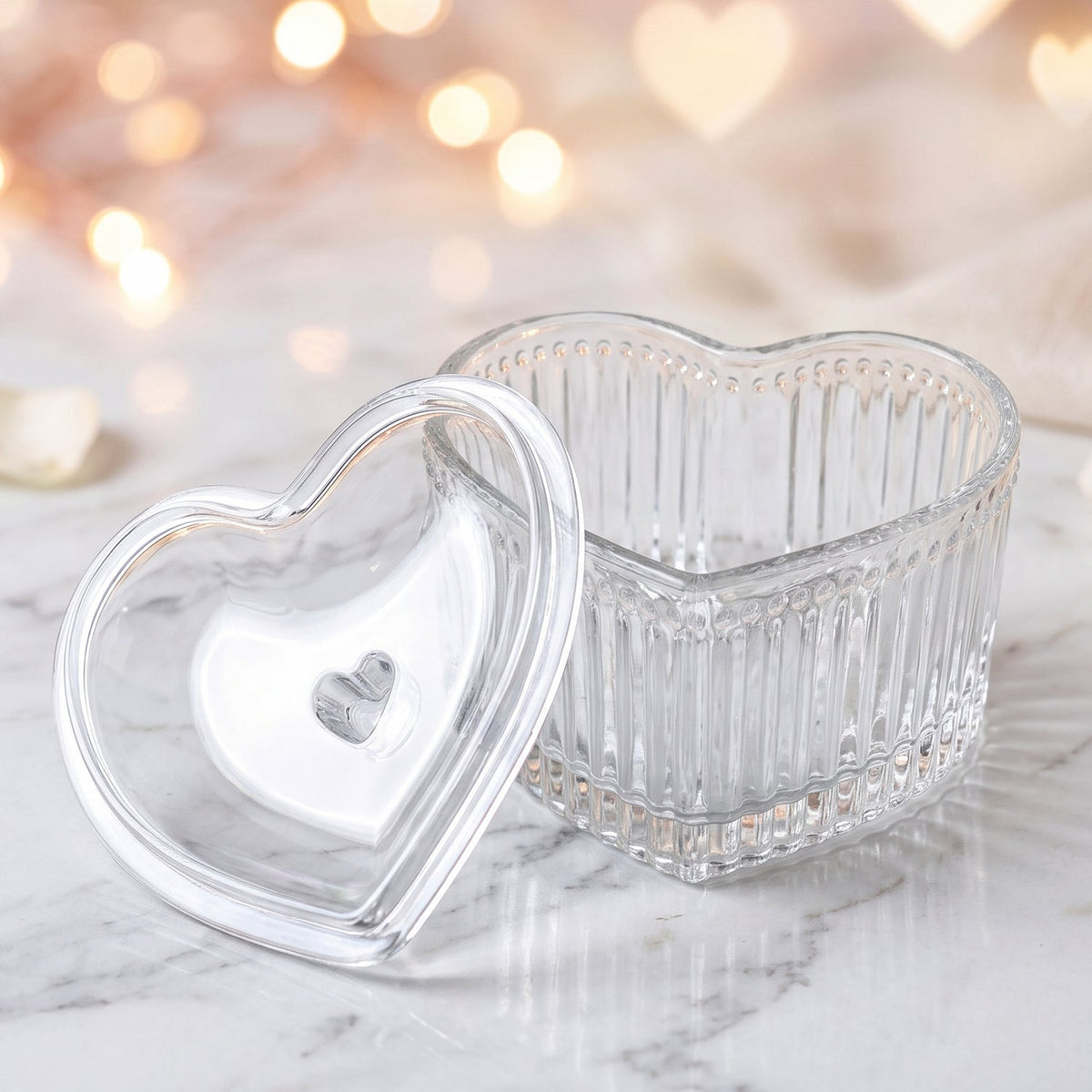 Six clear heart-shaped bowls with lids are packaged in a cardboard insert within a clear plastic container, next to an