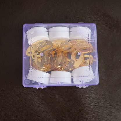 Six golden LED diya tealight candles with white bases packed neatly inside a clear purple plastic storage box.