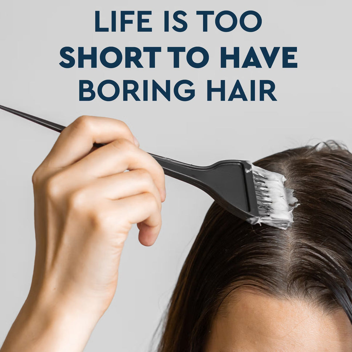 A hand applying hair dye to dark hair with a black brush, with the text "LIFE IS TOO SHORT TO HAVE BORING HAIR" above.