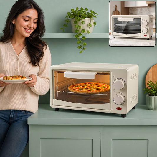 A woman holds a slice of pizza while a whole pizza bakes inside a cream-colored mini oven on a green counter.