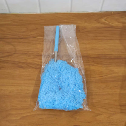 A blue microfiber duster with an extendable handle is packaged in clear plastic on a wooden surface.