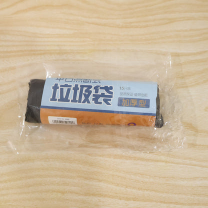 A clear plastic-wrapped roll of black garbage bags with a blue and brown label on a wooden surface.