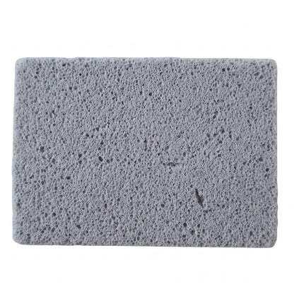 Close-up, top-down view of a rectangular gray cleaning block with a porous texture on a white background.
