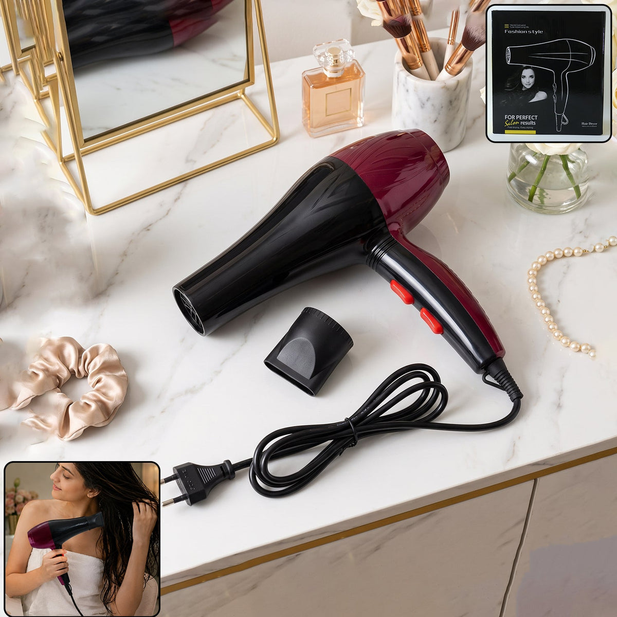 A red and black hair dryer with a concentrator nozzle and power cord rests on a marble vanity with accessories.