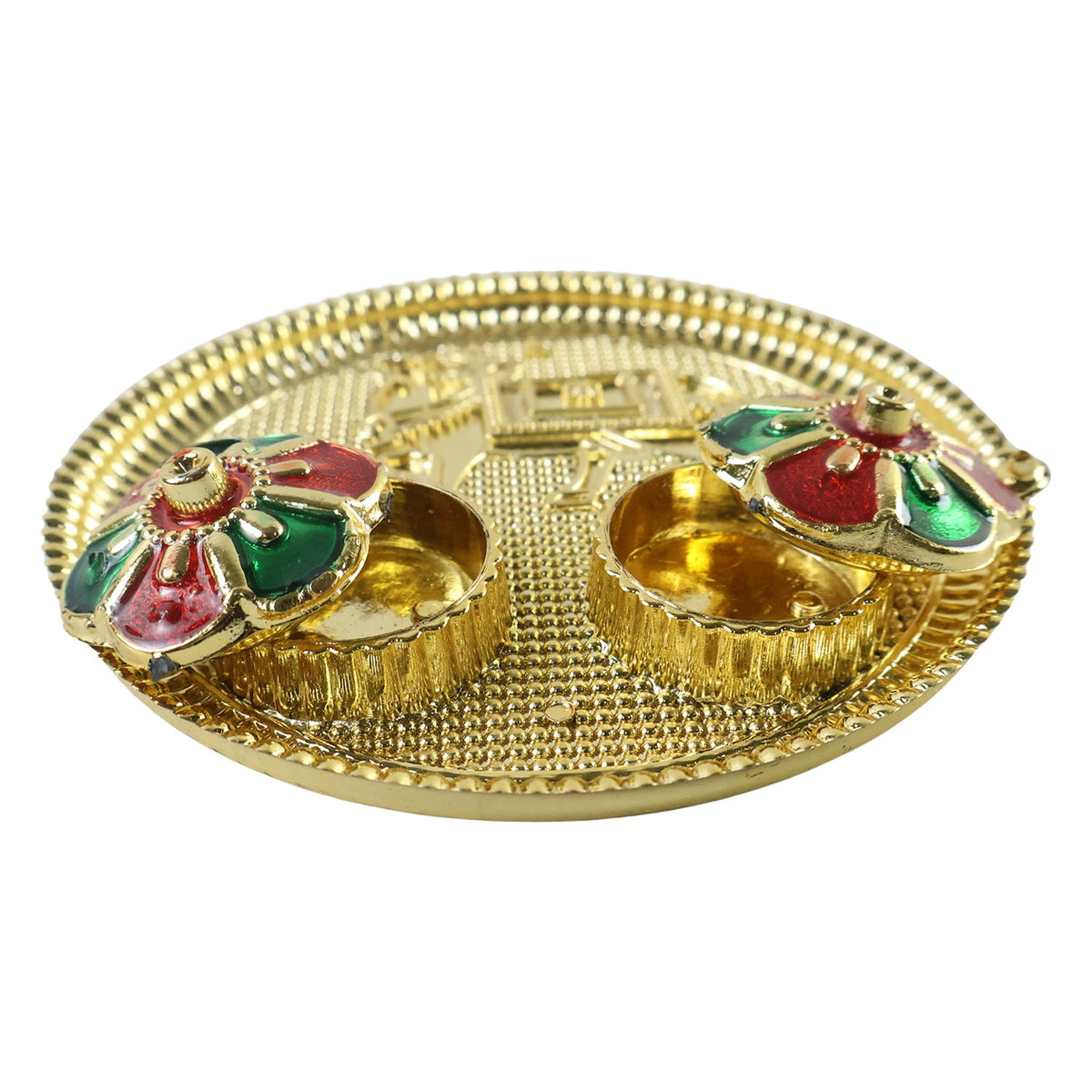 A side view of a golden pooja thali with an embossed cow design and two small empty bowls with colorful flower-shaped lids.
