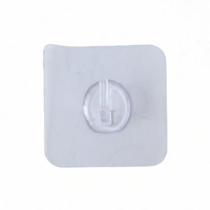 A close-up, top-down view of a single clear self-adhesive wall hook on a white background.
