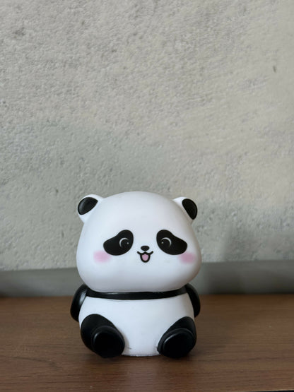 Cute panda LED night lamp placed on wooden bedside table