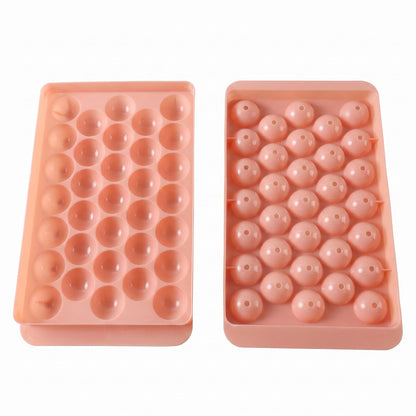 Two pink plastic ice ball trays, one with open spherical molds and the other with covered molds.