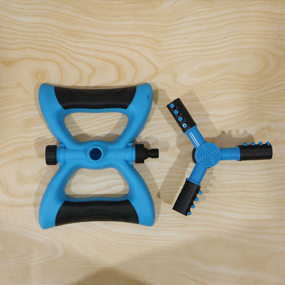 Blue and black rotating lawn sprinkler in daily garden use
