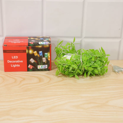 A red box labeled "LED Decorative Lights" and a coiled bundle of green leaf string lights with a plug on a light wooden