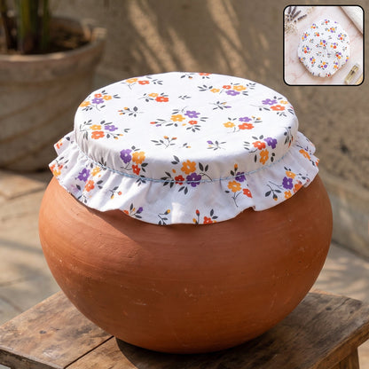 White cotton food cover with small colorful flower print on a terracotta pot outdoors.