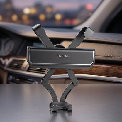 A black car phone holder with an extendable arm mechanism, sitting on a car dashboard at night