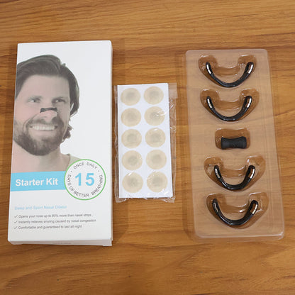 White box for nasal dilator starter kit, a small bag of beige circular patches, and a clear tray with four black nasal