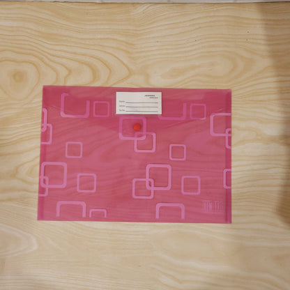 A pink plastic document folder with a button closure and a white label, centered on a light wooden surface.