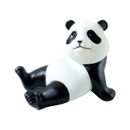 A black and white panda figurine with a slight smile sits on a white background, looking forward.