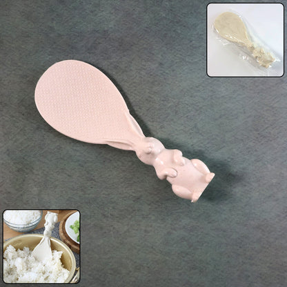 A pinkish-beige bunny-handled rice spoon lies on a dark gray surface; insets show it wrapped and scooping rice.