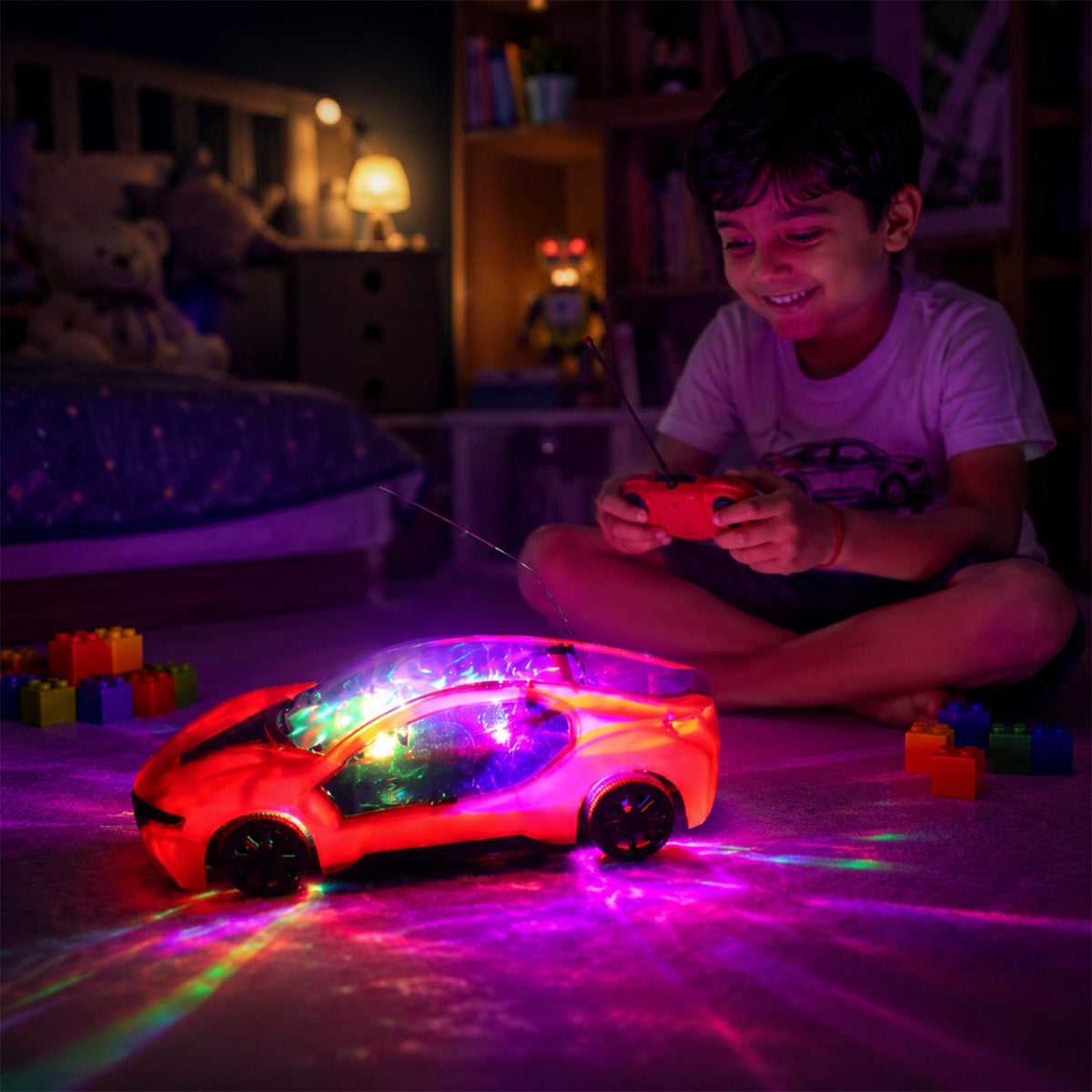 A young boy smiles while playing with a red remote control car that projects colorful lights onto the carpet in a dimly lit
