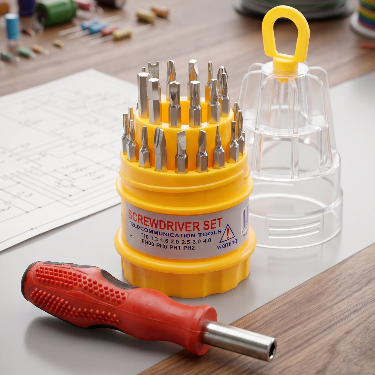 A red and black screwdriver and a yellow and clear screwdriver set with various bits are on a wooden and grey table with a