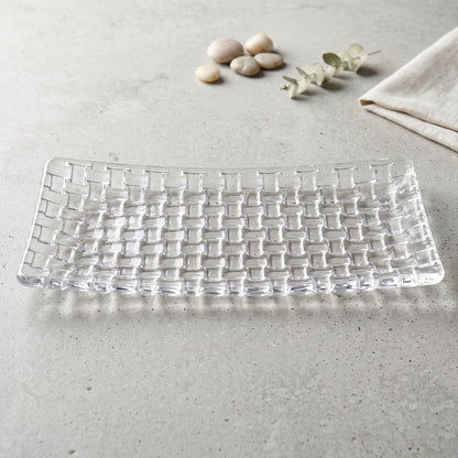 Rectangular clear glass serving platter with a textured basketweave design on a light gray surface.