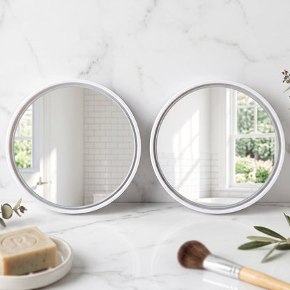 Two round white-framed mirrors on a white marble counter with soap and a makeup brush.