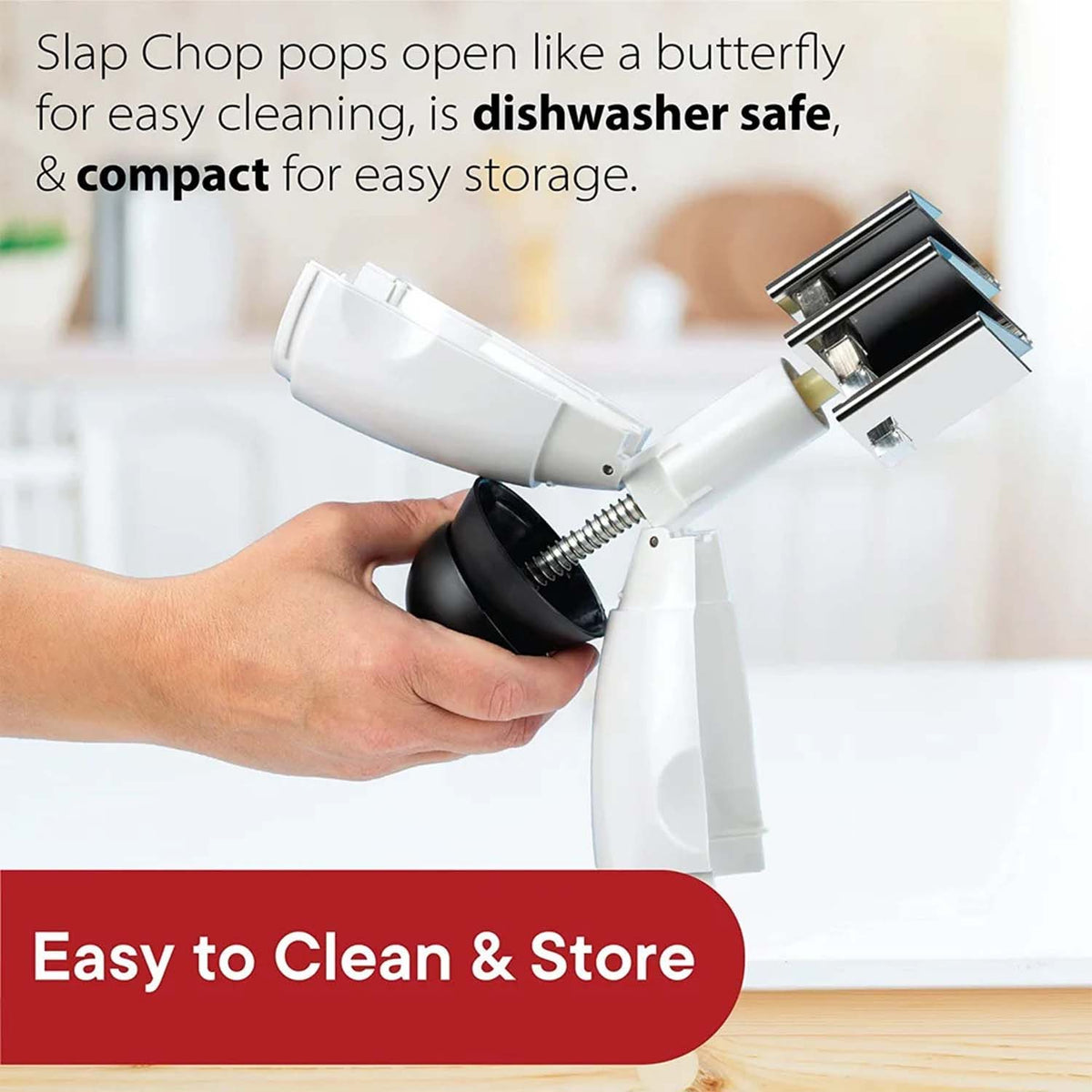 A person's hand holds the disassembled manual food chopper, illustrating its butterfly-like opening for cleaning.