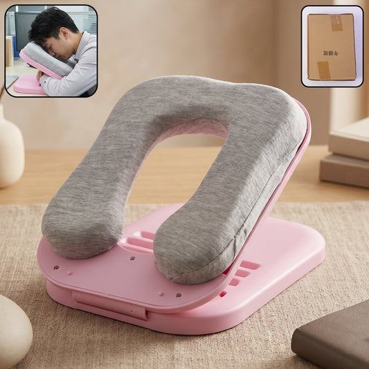 A pink foldable desktop nap pillow with a gray fabric cushion, shown with a person sleeping on it in an inset.