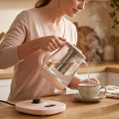 The electric kettle and its packaging box are displayed side-by-side on a light wooden surface against white tiles.