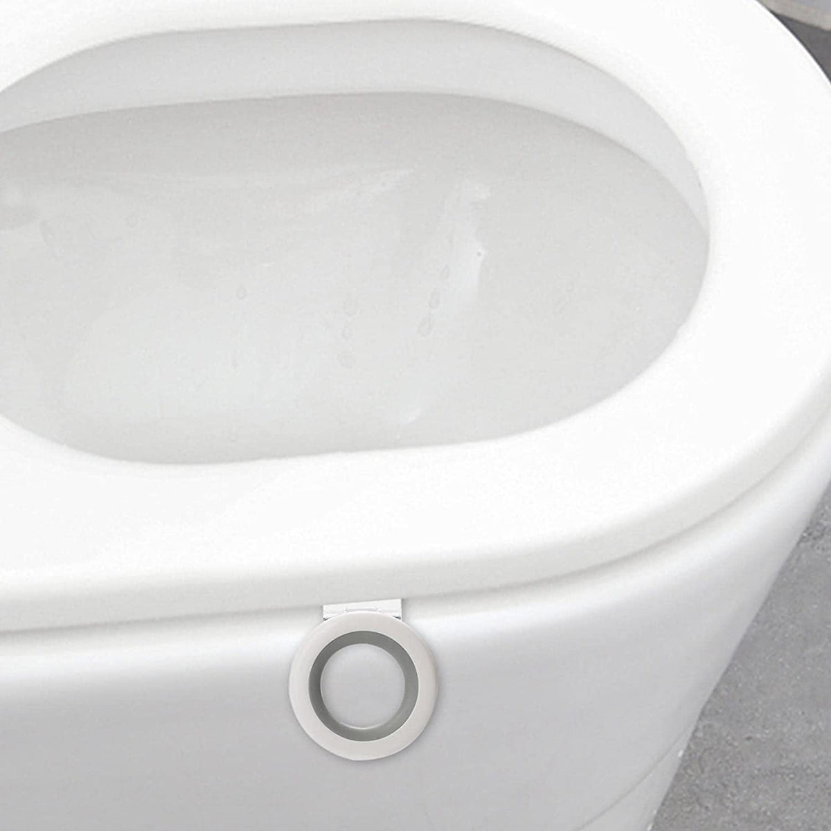 A close-up of a white toilet with the white and gray toilet seat lifter attached to the front of the seat.