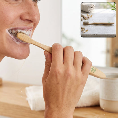 A woman brushes her teeth with a bamboo toothbrush, a small inset shows the toothbrush on a stone surface.