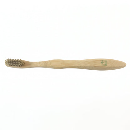 A light brown bamboo toothbrush with gray bristles is centered on a plain white background.