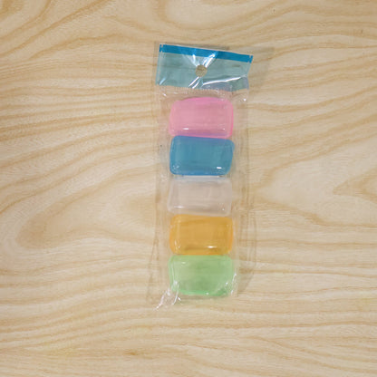 A clear plastic package contains five stacked translucent toothbrush head covers in pink, blue, clear, yellow, and green.
