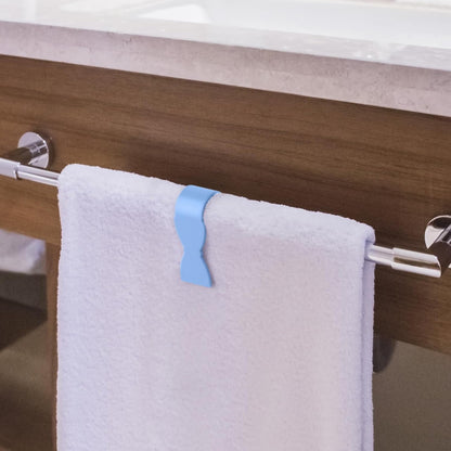 A blue towel clip holding a white towel on a chrome towel rail in a bathroom setting.