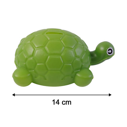 A green plastic turtle money bank isolated on white, with a black arrow indicating its 14 cm length.