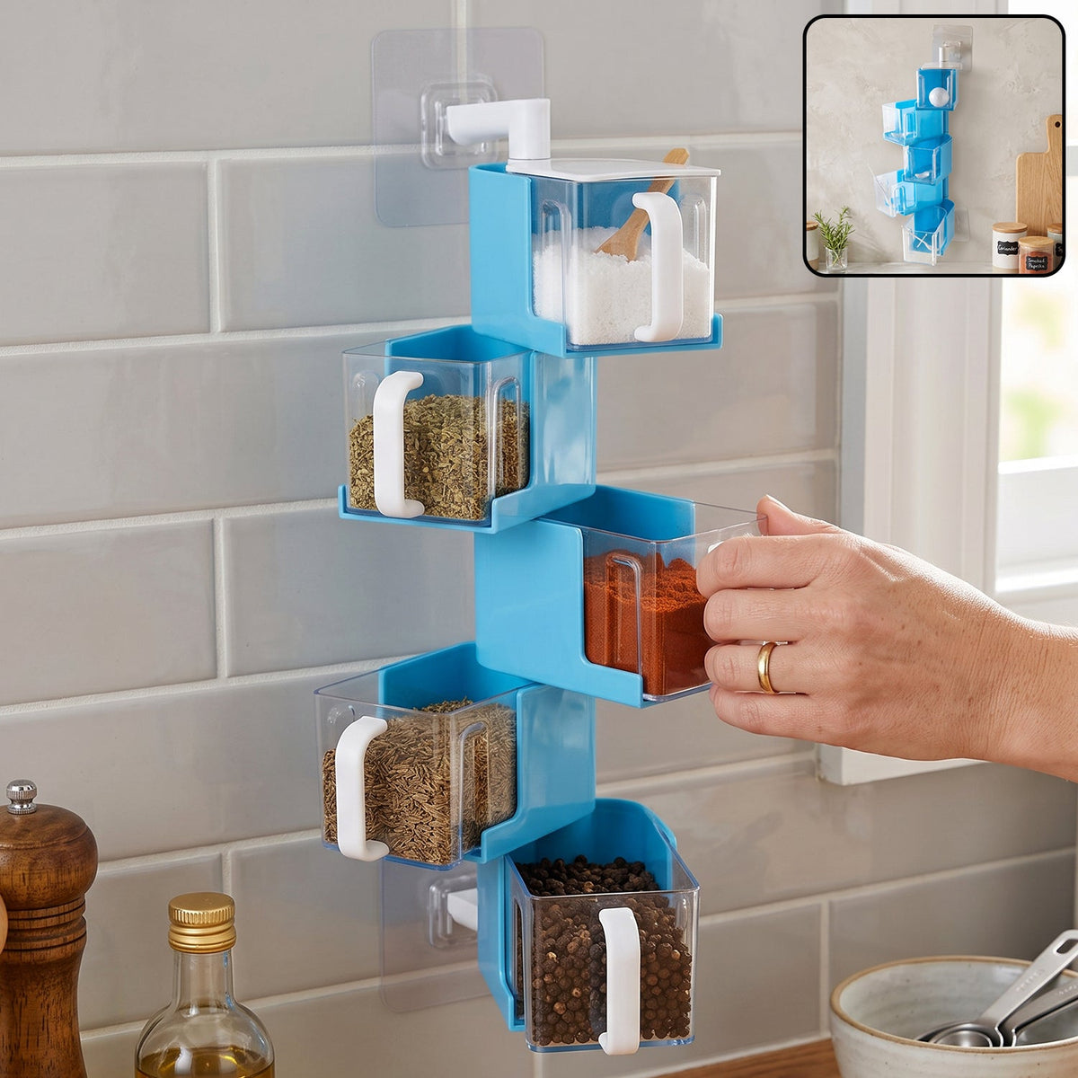 A hand pulls out a clear container of red spice from a blue 5-layer rotating spice rack on a tiled wall