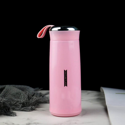 A pink vacuum flask with a silver lid and pink strap sits on a marble surface next to a grey cloth.