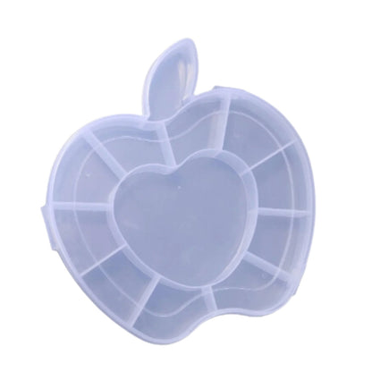 A translucent white apple-shaped organizer box with internal compartments, including a heart-shaped center, is shown against