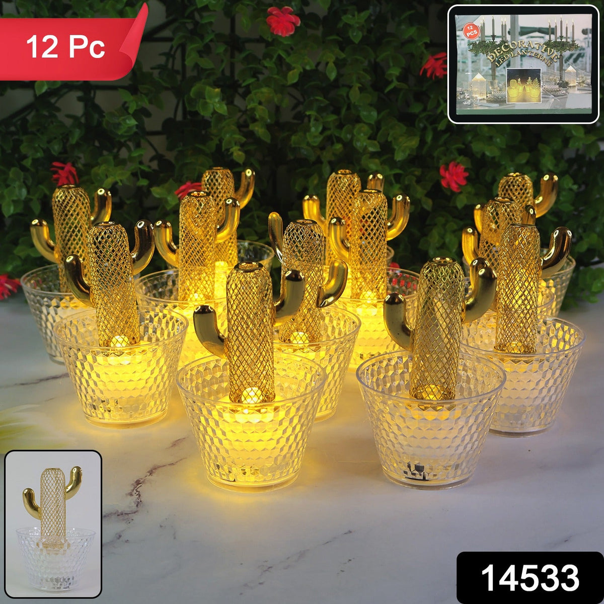 A set of twelve gold cactus LED tealights with clear bases glows on a white surface, with green plants in the background.