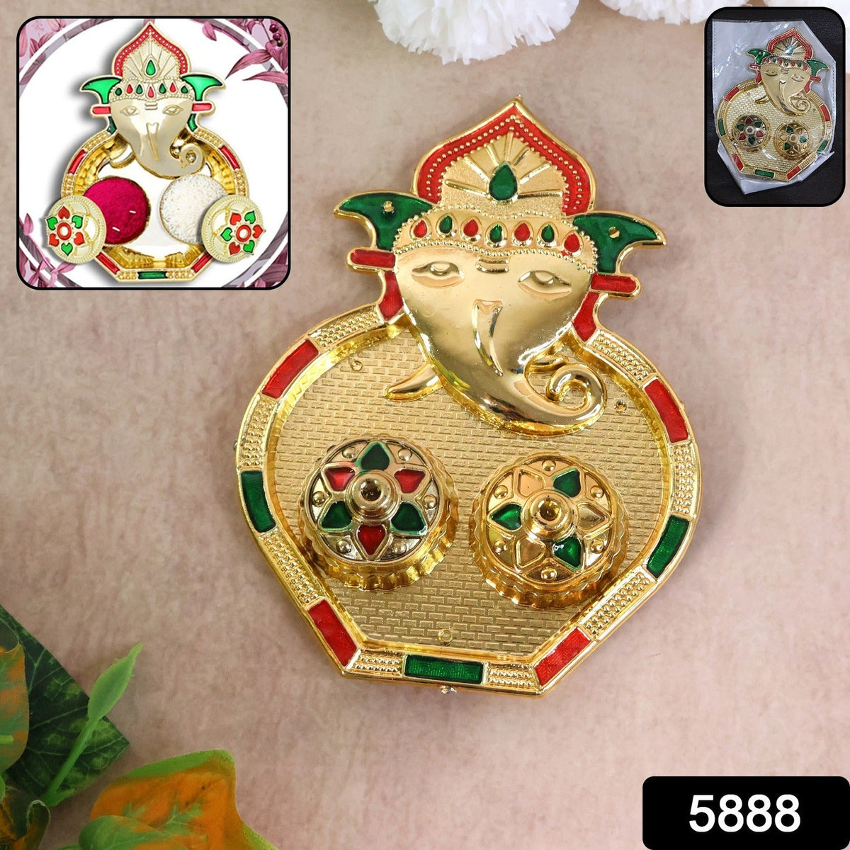 A golden Ganesh pooja thali with two small round containers, accented with red and green enamel details, with a small inset