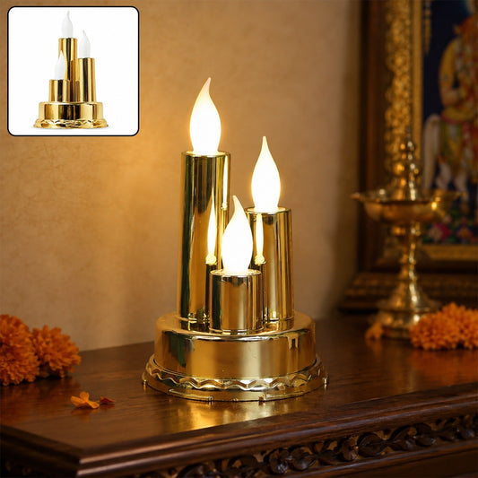 A golden triple LED flameless candle lamp glows warmly on a dark wooden surface with orange flowers.