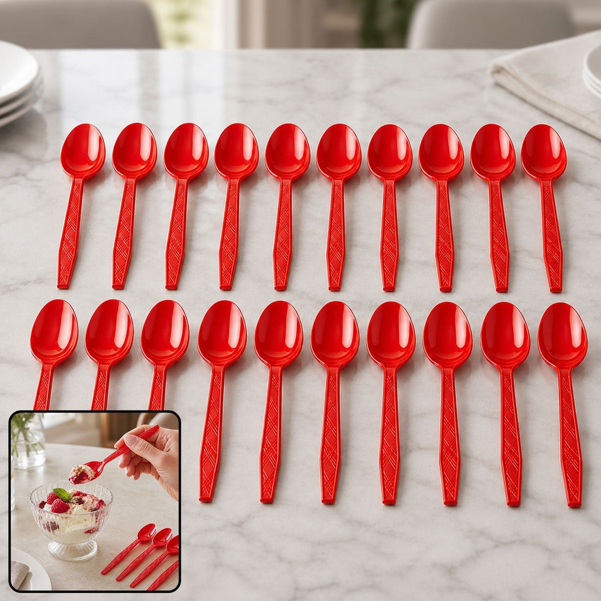 Twenty red plastic spoons arranged in two rows on a white marble table with plates in the background.
