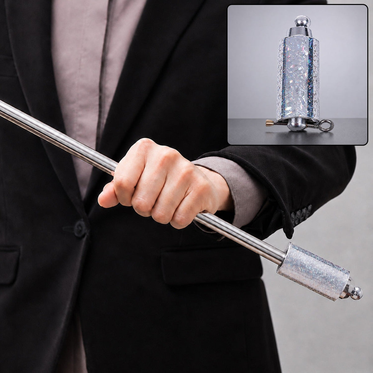 A person in a black suit holds a silver collapsible cane, with an inset showing the cane in its compact form.
