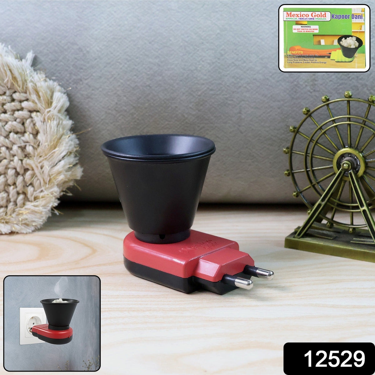 A red and black electric Kapoor Dani diffuser on a wooden surface with a decorative Ferris wheel and box.