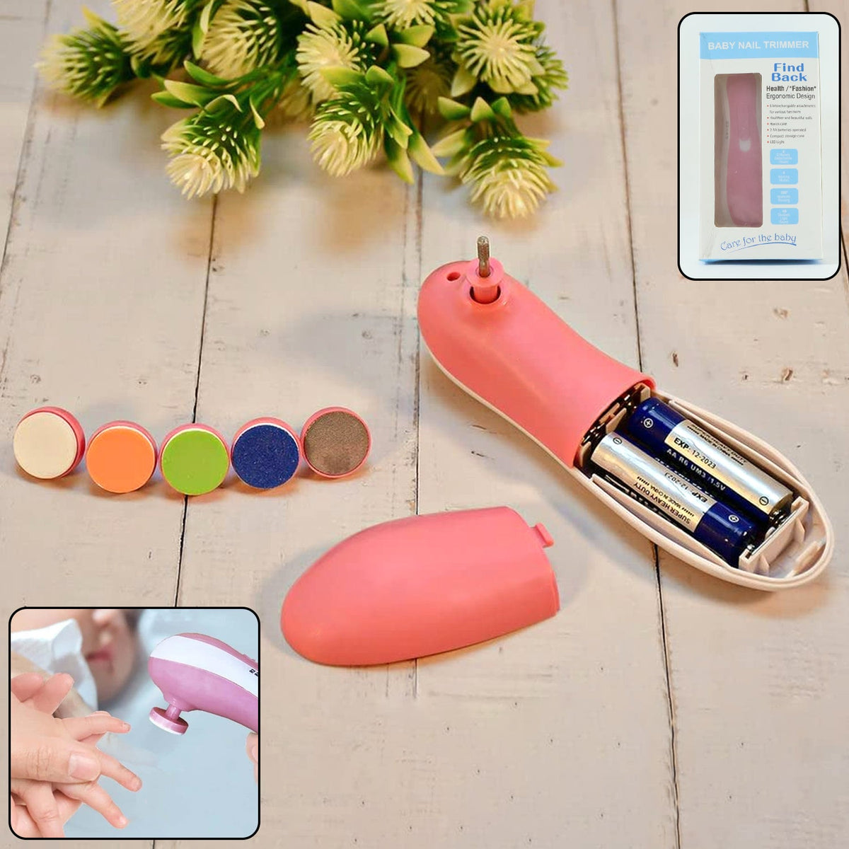 A pink electric nail trimmer, its battery compartment open, with five grinding heads and product box on wood.